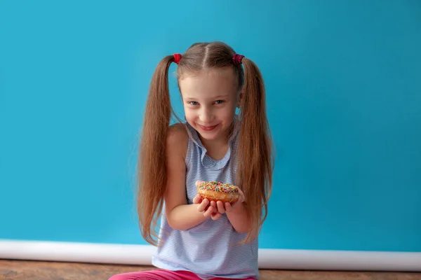 Chica con rosquilla de chocolate. Sonríe . —  Fotos de Stock