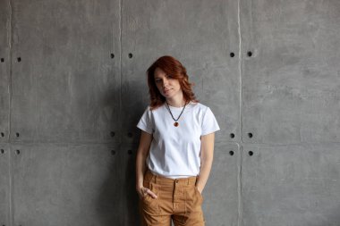 Beyaz tişörtlü ve bej pantolonlu genç kız..