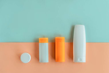 Yüz ve vücut için kozmetik spreyi, sarı ve mavi arka planda işaretlenmemiş boş paketler. Üst görünüm