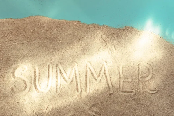 太陽の光でテキスト夏と青の紙の背景に砂 トップビュー 休暇の概念 — ストック写真