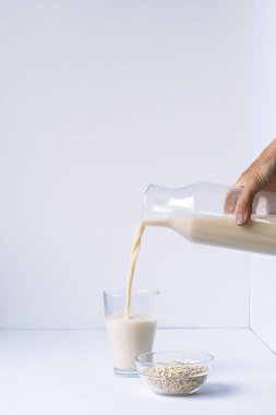 Sütün döküldüğü ve yulafların beyaz masaya döküldüğü bir bardak..