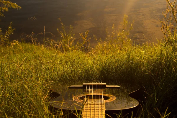 Czarna Gitara Trawie Zachodzie Słońca — Zdjęcie stockowe