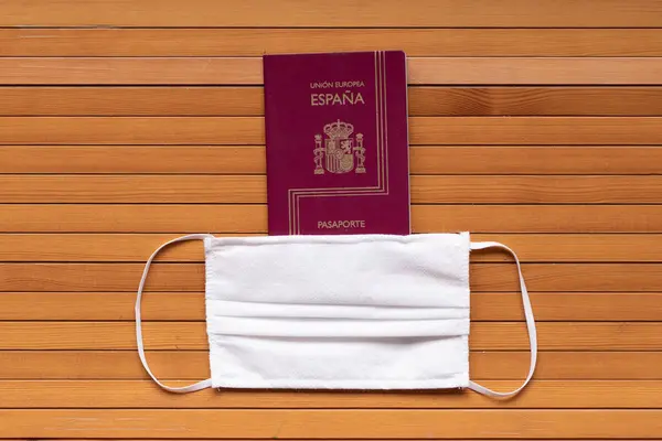 Passaporte Espanhol Usando Máscara Protetora Médica Mesa Madeira — Fotografia de Stock