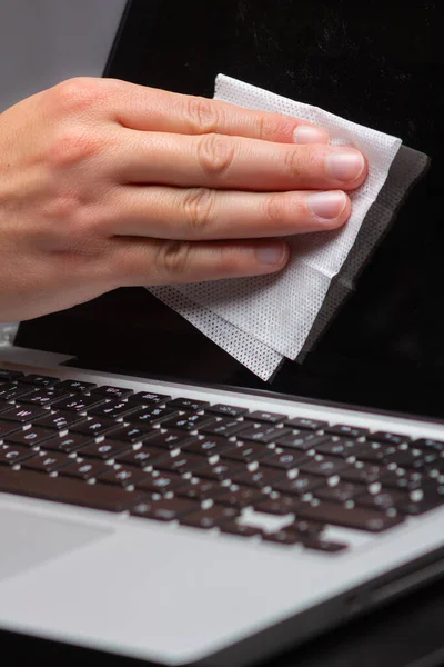 Cleaning a computer with a damp cloth to eliminate germs.