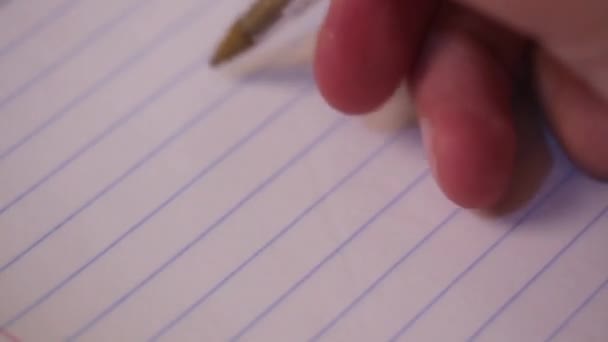 一个人的手拿着一支笔 在带条纹的笔记本上写字 写在他的日记或信里 做作业 写下一天的耳环 — 图库视频影像