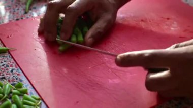 Aşçının yemek saatinde mutfakta yeşil fasulye doğraması.