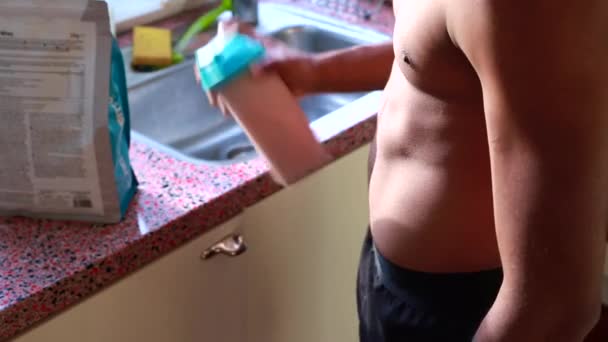 タンパク質シェイクを作る若い男の動きが遅い — ストック動画