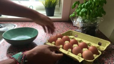 Evde omlet yapan genç adam yavaş hareket ediyor.