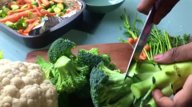 Vejetaryen yemeği için brokoli doğrayan kişi yavaş hareket eder.