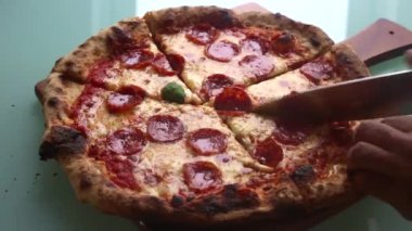 Adam akşam yemeği için evde pizza yapıyor.