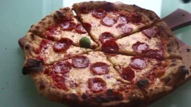 Adam akşam yemeği için evde pizza yapıyor.