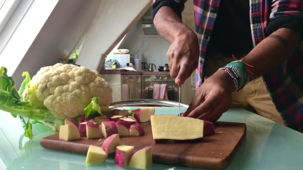 男は昼食のために家で野菜を切る — ストック動画
