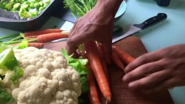 Öğle yemeği için sebze doğrayan bir erkeğin yüksek açılı görüntüsü.