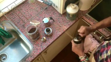 En tepedeki kişi moka po ile espresso kahvesi yapıyor.