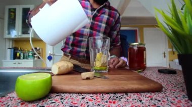 Düşük görüşlü insan mutfakta zencefilli limon çayı yapıyor.
