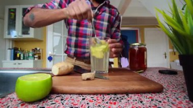 Düşük görüşlü insan mutfakta zencefilli limon çayı yapıyor.