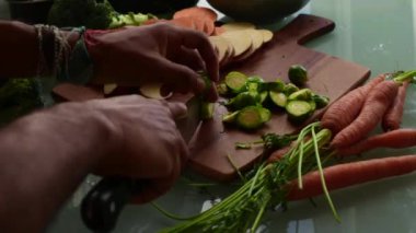 Tahta kesme tahtasında taze sebze doğramak.