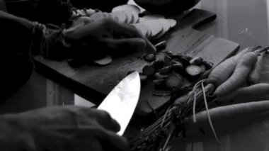 Tahtada sebze doğrayan eller.