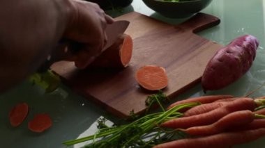 Tahtada tatlı patates dilimliyorum.