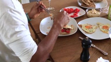 Tabakta domatesle yemek yiyen bir insan.