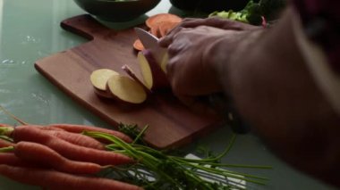 Tahtada tatlı patates dilimliyorum.