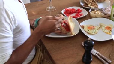 Taze domatesli sandviç hazırlayan kişi.