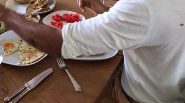 Domatesli ve krepli yemeğin tadını çıkaran kişi