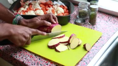 Yeşil kesme tahtasında tatlı patates dilimlemek