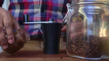 Mutfakta kahve çekirdeklerini öğüten kişiye yakın çekim.