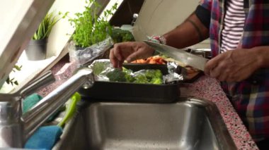 Mutfak lavabosunda sebze hazırlayan kişi