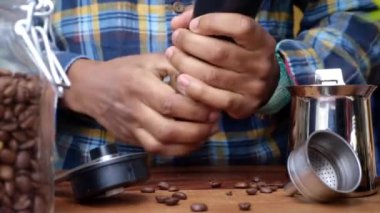 Mutfakta kahve çekirdeklerini öğüten biri.