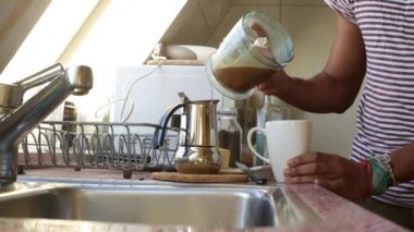 Kahvaltıda evde tereyağlı kurşun geçirmez kahve yapan kişi.