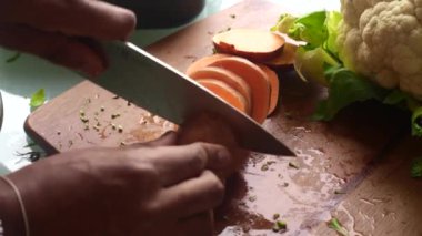 Adam çeşitli sebzeleri pişirmek için hazırlıyor.