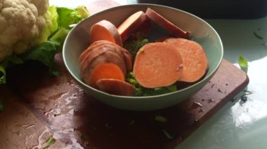 Adam çeşitli sebzeleri pişirmek için hazırlıyor.