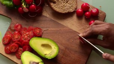 Tahtada domates ve avokado dilimliyorum.