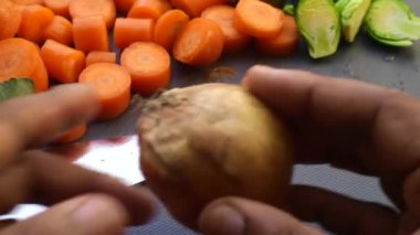 Evde sebze doğrayan insan ellerine yakın çekim.