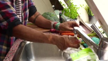 Pişirmeden önce sebze yıkayan birini kapat.