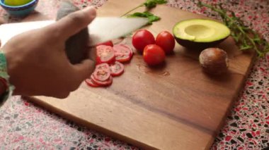 Top view of person making healthy meal with avocado and tomatoes
