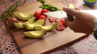 Top view of person making healthy meal with avocado and tomatoes