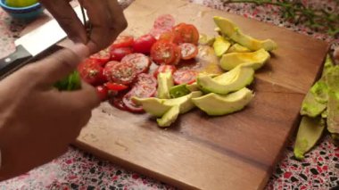 Top view of person making healthy meal with avocado and tomatoes