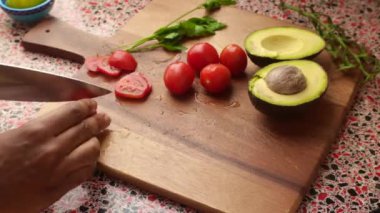Top view of person making healthy meal with avocado and tomatoes
