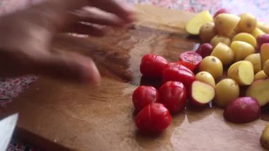 Evde pişirmek için kiraz domateslerini doğrayan kişiye yaklaş.