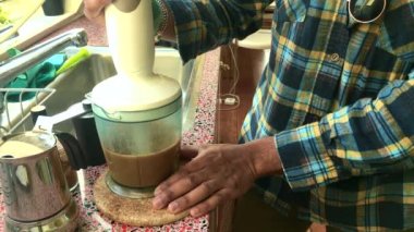  Evde otla beslenmiş tereyağlı kahve yapan biri.