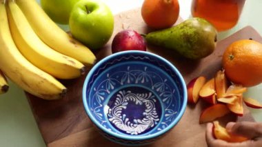 Üst düzey yetişkin evde sağlıklı meyve salatası yapıyor.