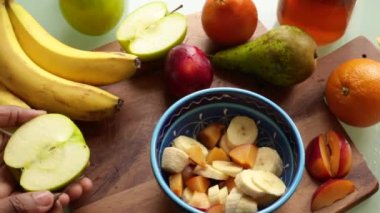 Evde nefis meyve salatası yapan insan manzarası.