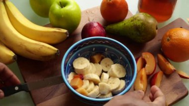 Evde sağlıklı meyve salatası yapan kişi.
