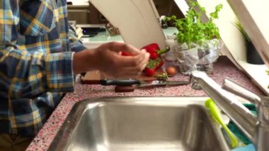 Yetişkin bir adamın evde taze sebzeler hazırlamasına yakın çekim.