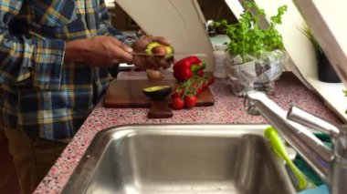 Evde pişirmek için sebze hazırlayan kişiye yakın çekim.