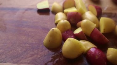 Tahtada bebek patatesleri hazırlayan kişinin elleri.