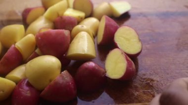 Tahtada bebek patatesleri hazırlayan kişinin elleri.